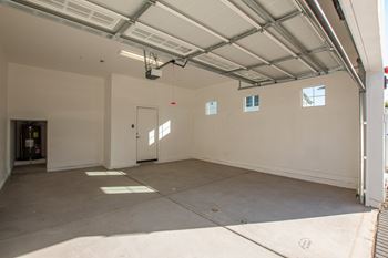 A large, empty garage with a concrete floor and white walls.